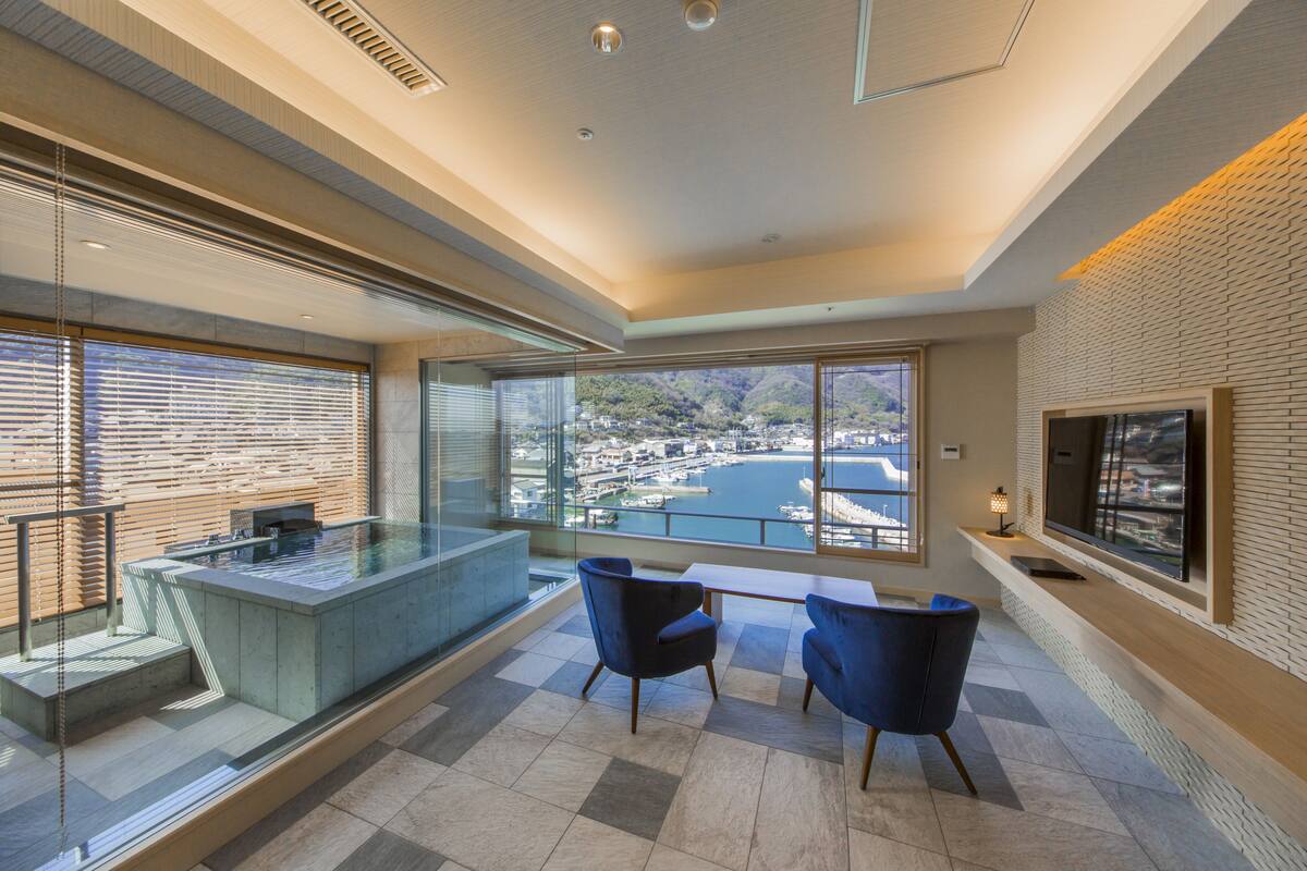 A modern interior with a large window offering a view of a marina and mountains.