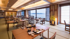 A traditional Japanese restaurant with tatami mat flooring, wooden furniture, and a view of the sea. - Hotel Ofutei (Fukuyama)