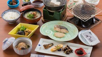 Diversos platos japoneses, como sushi, arroz y sopa, dispuestos sobre una mesa de madera.