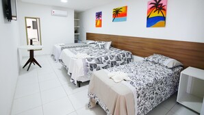 A hotel room with two beds, a small table, a TV, and artwork on the walls. - Pousada Brasileira (Ipojuca)
