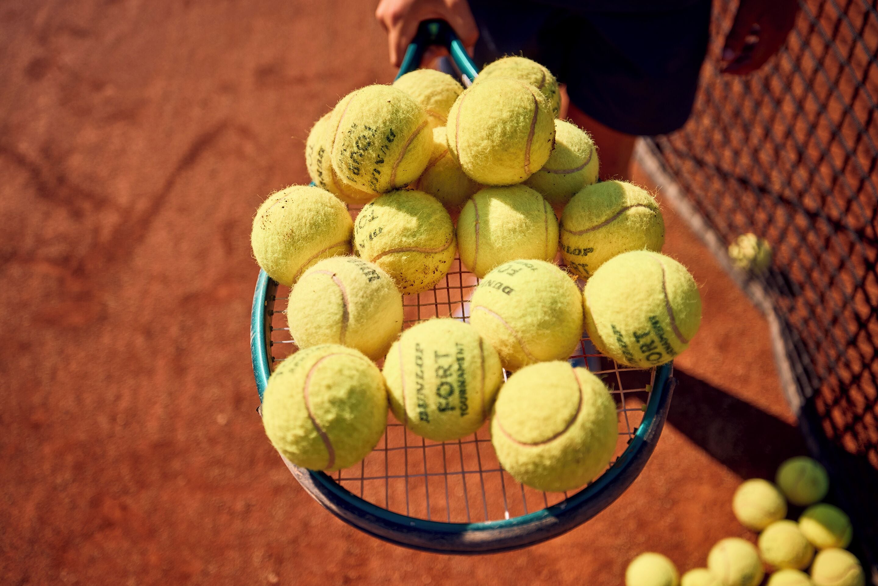 Ein Tennisschläger voller Tennisbälle.