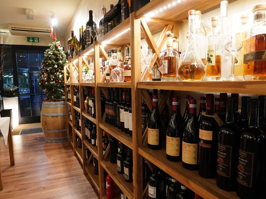A wine cellar with wooden shelves stocked with various bottles.