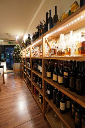 Une cave à vin avec des étagères en bois remplies de différentes bouteilles.