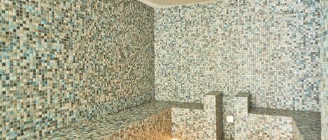 A room with mosaic tile walls and a bench.