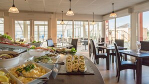 Un buffet proposant divers plats, ainsi qu’un espace repas avec des tables et des chaises.