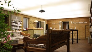 Une pièce chaleureuse avec un banc en bois, un canapé et une étagère contenant des articles de toilette. On y trouve également un miroir et une table avec des chaises.