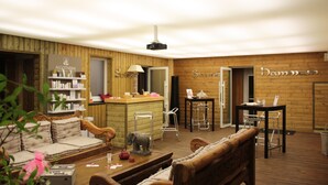 Un salon chaleureux avec un canapé, une table basse en bois et un coin bar équipé de tabourets.