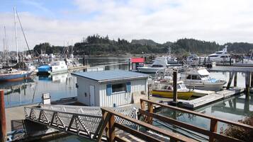 A marina with docked boats, a small building, and a wooden dock.