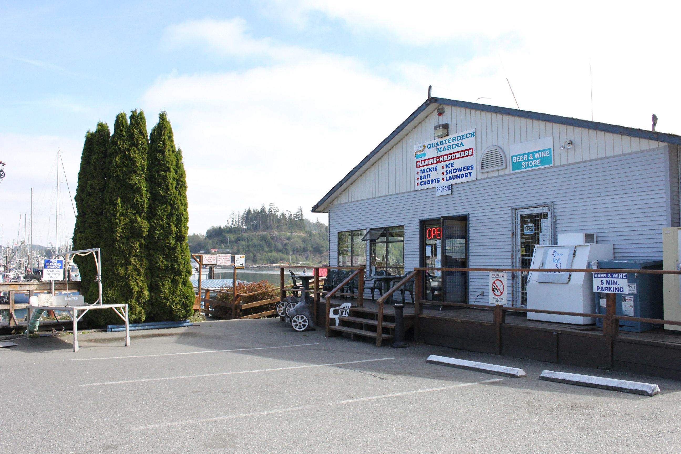 En byggnad med en skylt som visar att det är en småbåtshamn, en butik som säljer öl och vin samt en butik som säljer propan.