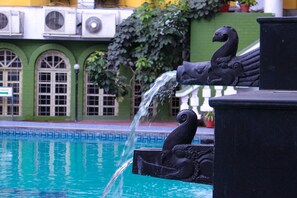 Ein Brunnen mit einer Skulptur eines schwarzen Schwans, aus dessen Schnabel Wasser sprüht.