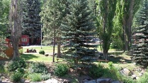 A natural outdoor setting with a stream, rocks, and trees. - Stoney River Lodge (Loveland)