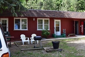 A red building with white-framed windows, a Coca-Cola sign, and outdoor seating. - Stoney River Lodge (Loveland)