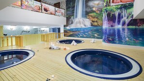 A spa area with multiple hot tubs and a large mural of waterfalls. - Green World Nha Trang Apartment (Nha Trang)