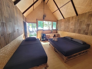 A room with two beds, a desk, and a window.