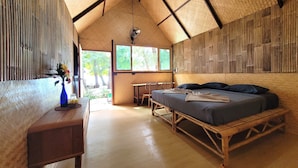 A room with a bed, a desk, and a chair. There is a window and a door leading outside. - Green View Beach Resort (Koh Lipe)