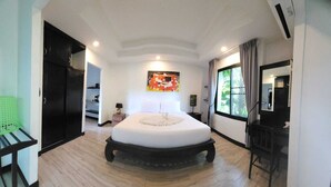 A spacious bedroom with a large bed, a wardrobe, a desk, and a window with curtains. - Cocoville Phuket Resort (Chalong)