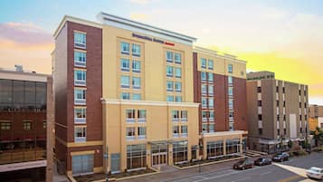 Welcome to Springhill Suites, a modern hotel with a covered entrance and spacious windows on each floor.