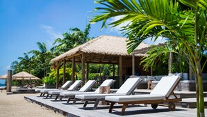 A beachside resort with thatched-roof huts and lounge chairs. - Paradise Beach Nevis (Cotton Ground)