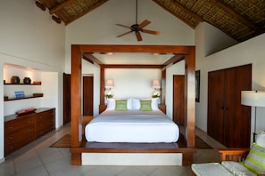 A bedroom with a four-poster bed, wooden furniture, and a ceiling fan.