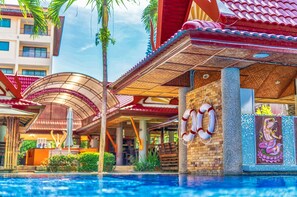 Un hotel con piscina, un flotador salvavidas y un mural de una figura mitológica.