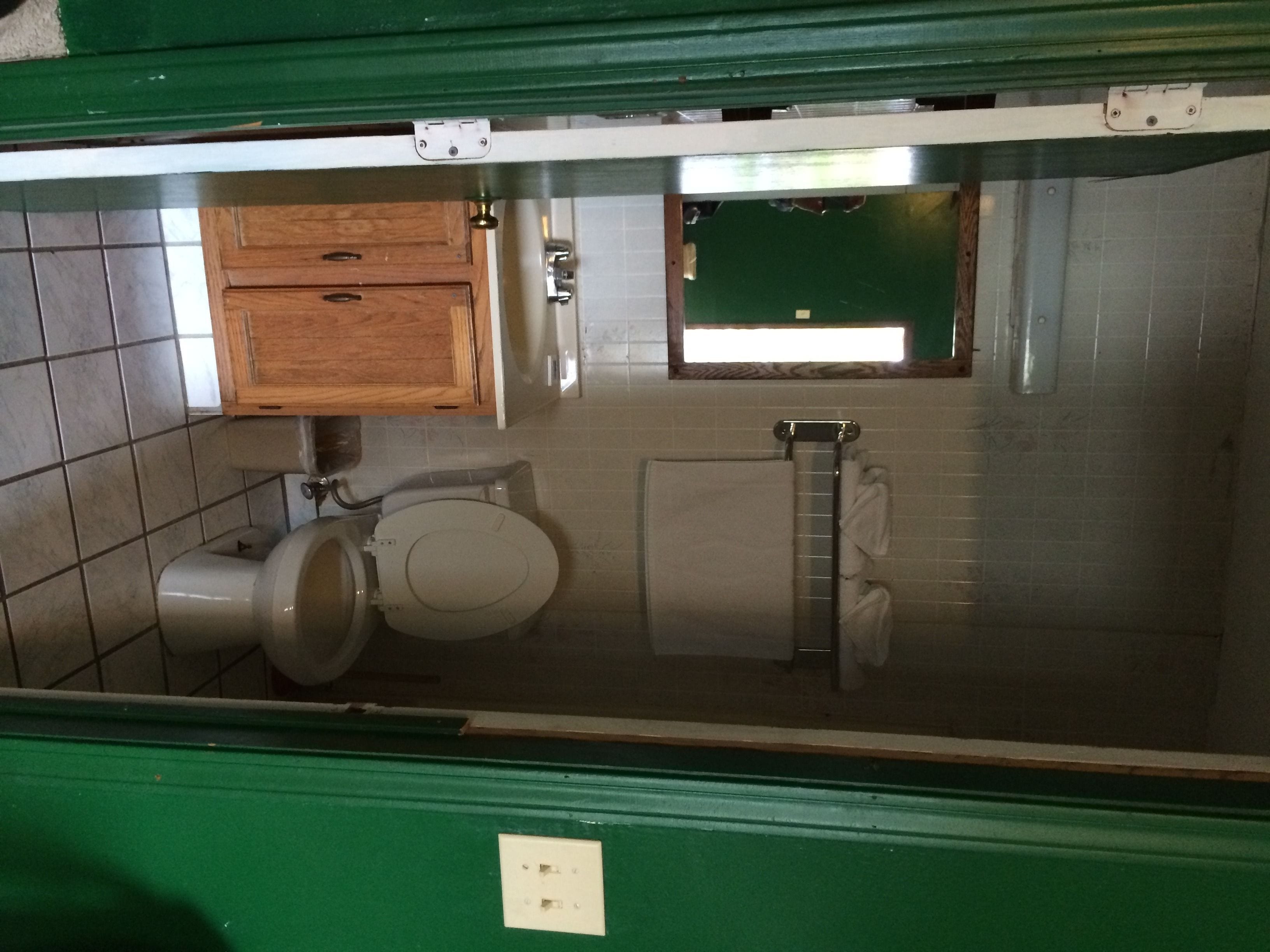 Une petite salle de bain comprenant des toilettes, un lavabo et un porte-serviettes.