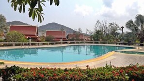 Una piscina al aire libre, sillones reclinables de piscina