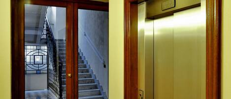 A wooden door leading to a staircase and an elevator.