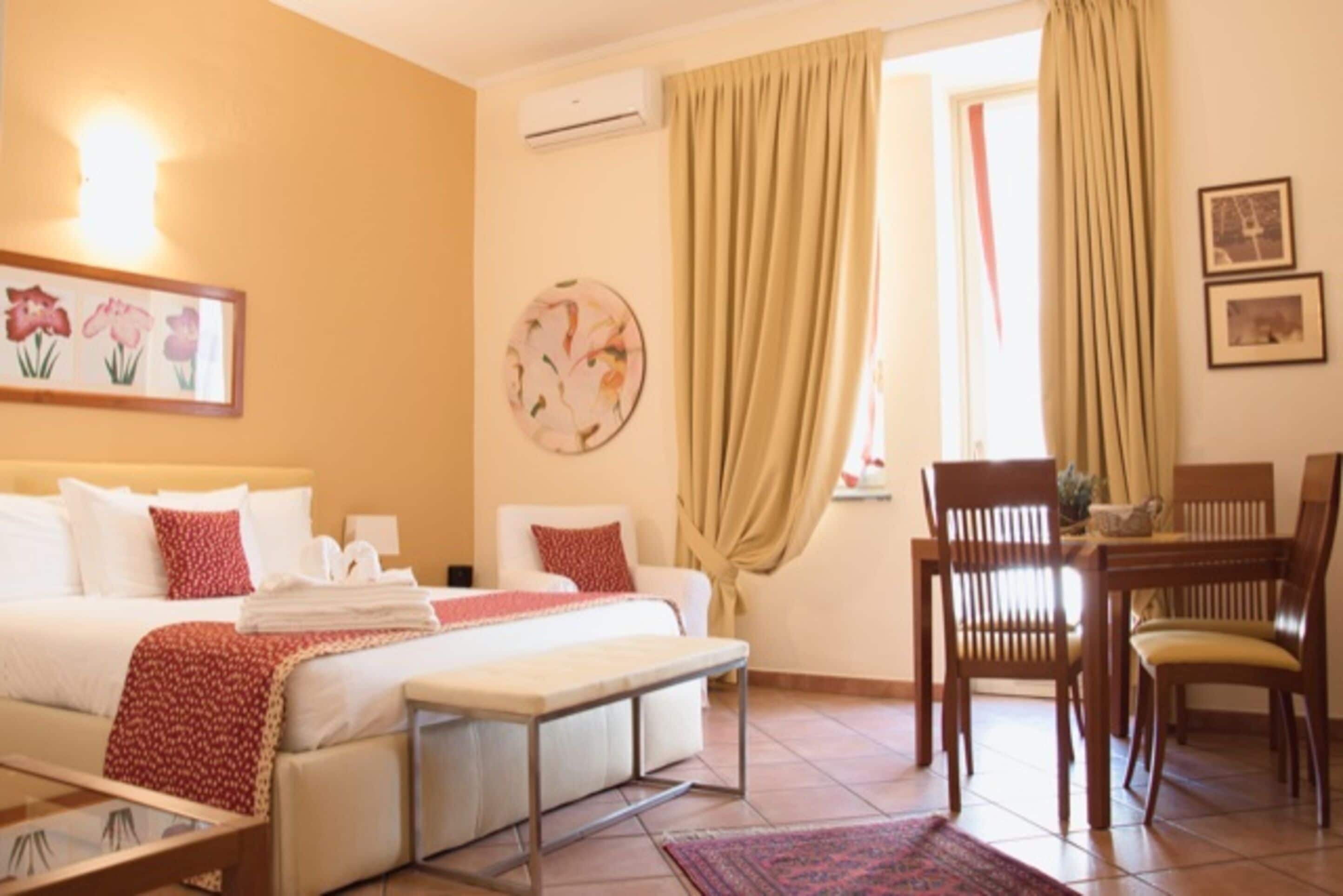 Une chambre d’hôtel comprenant un lit, une table de chevet, une chaise et un coin repas avec des chaises et une table.