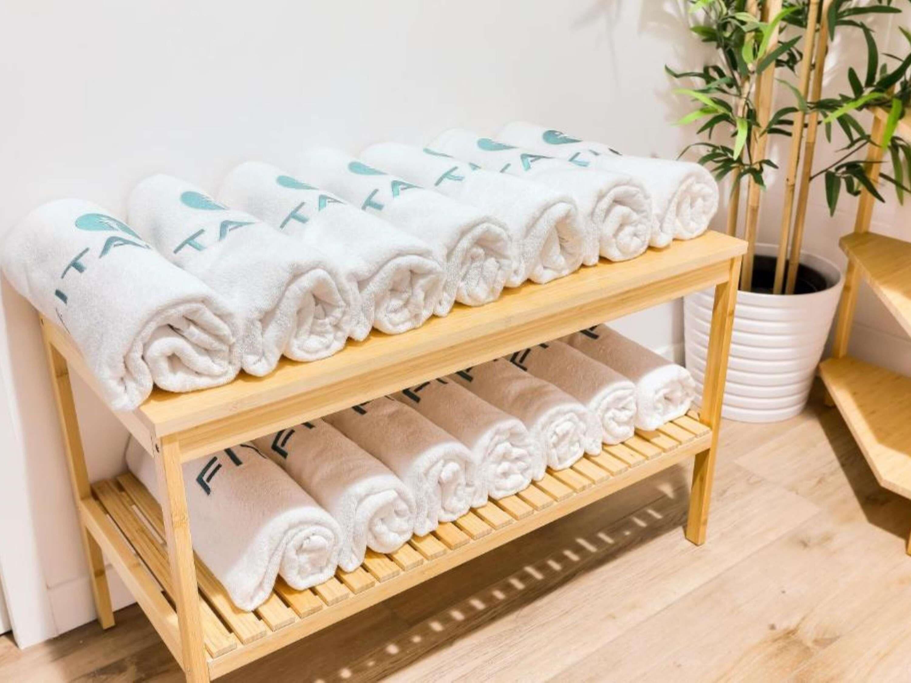 A wooden towel rack with neatly folded towels.