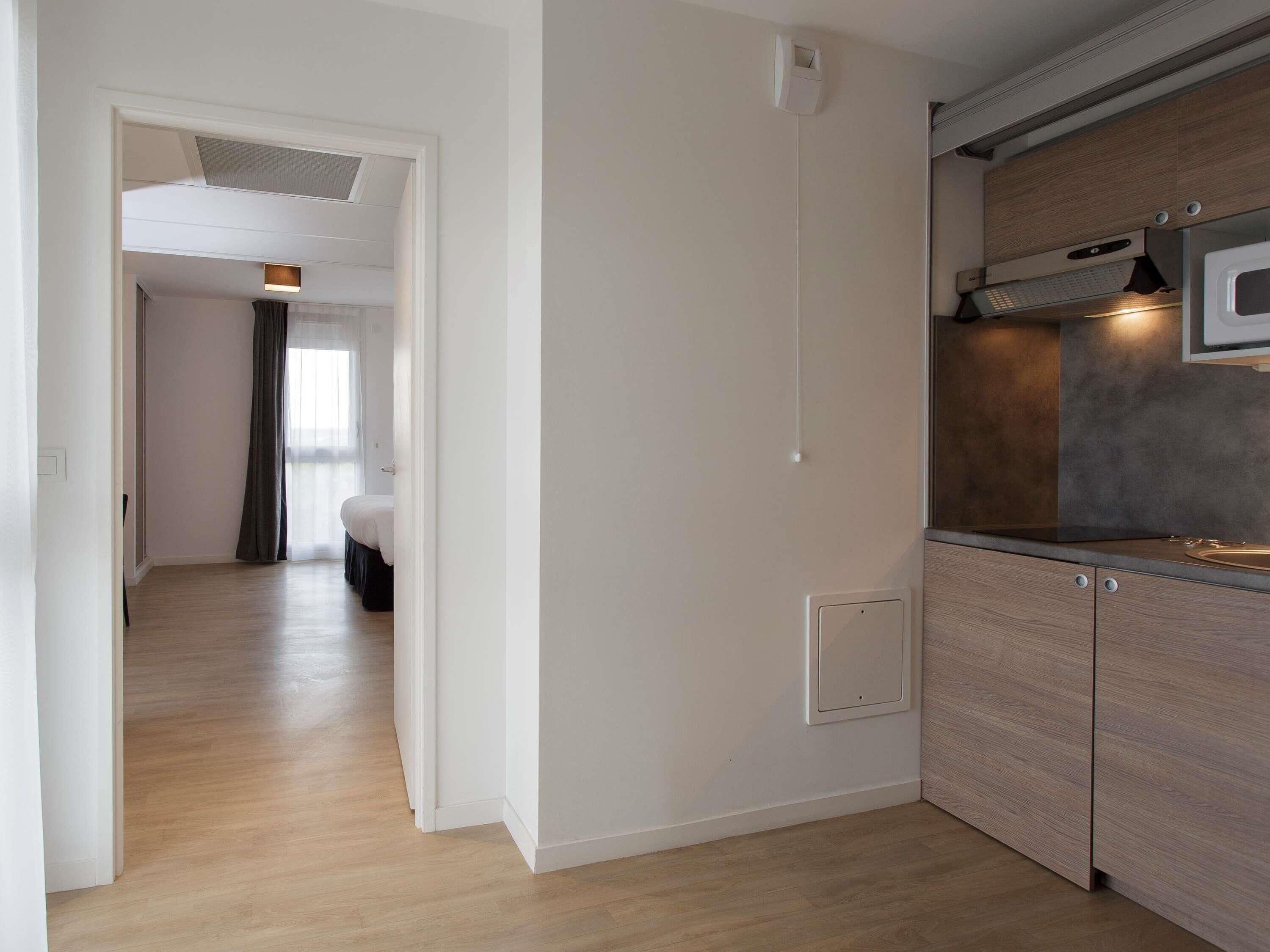 Una cocina moderna con microondas, horno empotrado y encimera de madera.