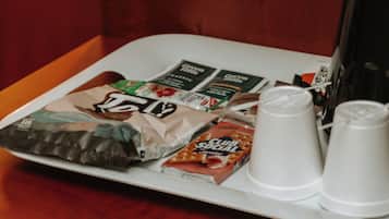 Una bandeja con tazas de café y sobres de café sobre una mesa de madera.