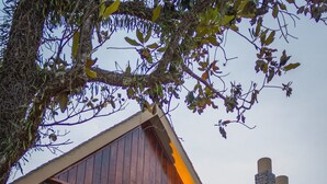 Een stenen huis met een houten dak, schoorsteen en een raam met een lattenwerk ontwerp.