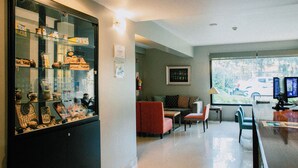 Een modern interieur met een glazen vitrine, zithoek en een scherm van een computer.