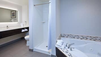 Une salle de bain moderne dotée d’une douche à l’italienne, d’une baignoire et d’un meuble-lavabo avec un miroir.