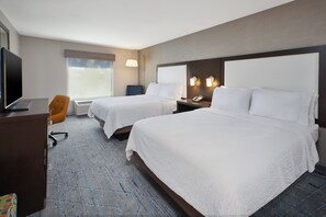 A hotel room with two beds, a desk with a television, a chair, and a window with blinds. - Holiday Inn Express & Suites Ann Arbor West by IHG (Dexter)