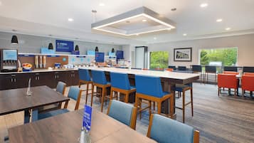 A modern breakfast area with a long counter, seating, and a view of the outdoors.