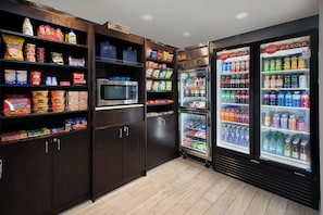A self-service food area with refrigerated beverage dispensers and a microwave. - Holiday Inn Express & Suites Ann Arbor West by IHG (Dexter)