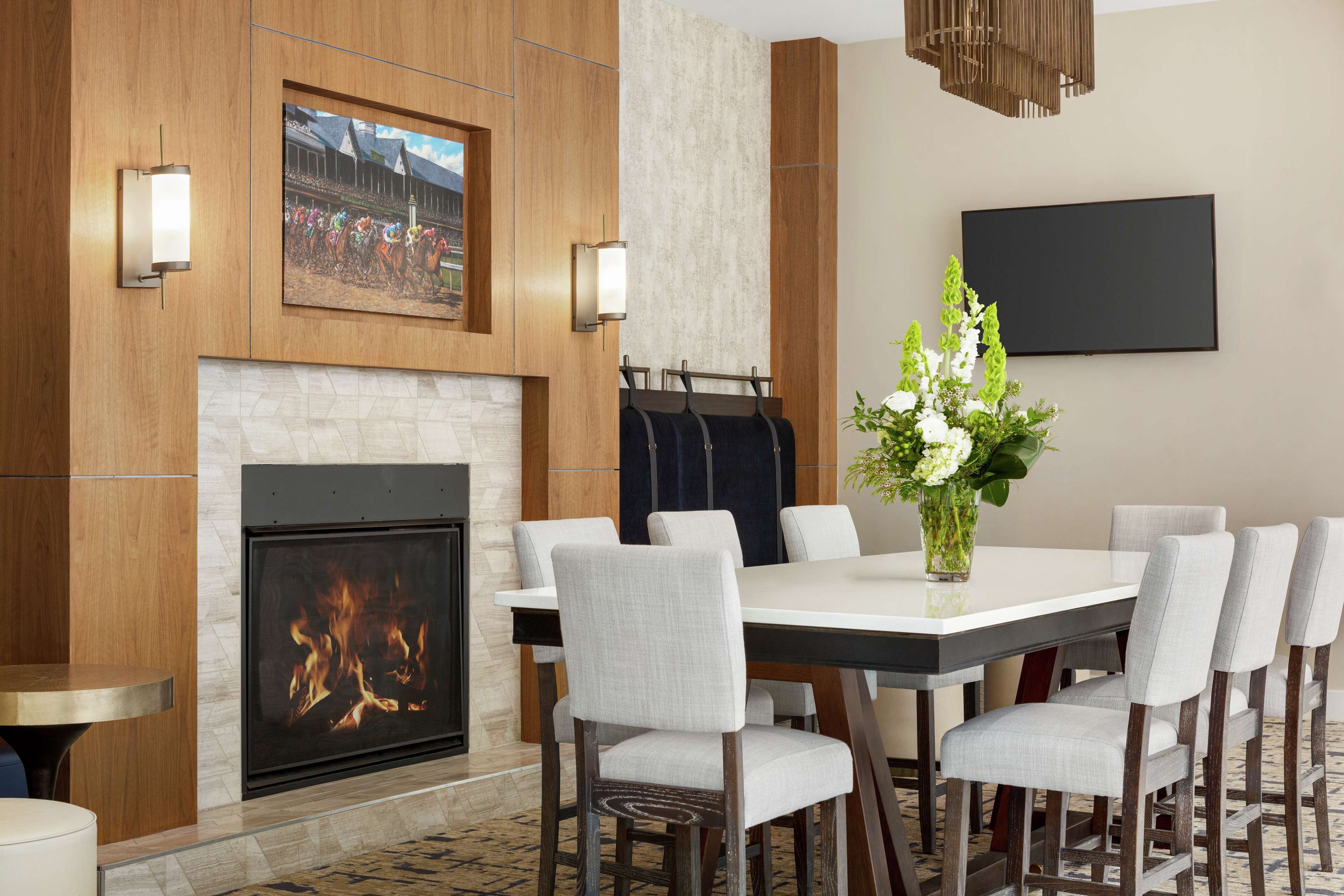 A modern dining area with a fireplace, a large table, and six chairs.