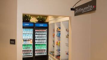 A hotel pantry with two refrigerators labeled "COLD" and a sign for "The Pavilion Pantry Snacks & Sundries".