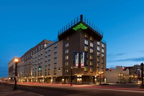 Un hotel de varios pisos con un letrero grande que dice 'Garden Inn', múltiples ventanas y una señal de tráfico que indica 'No Giro'.