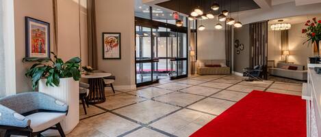 A spacious lobby with a red carpet, modern furniture, and large windows.
