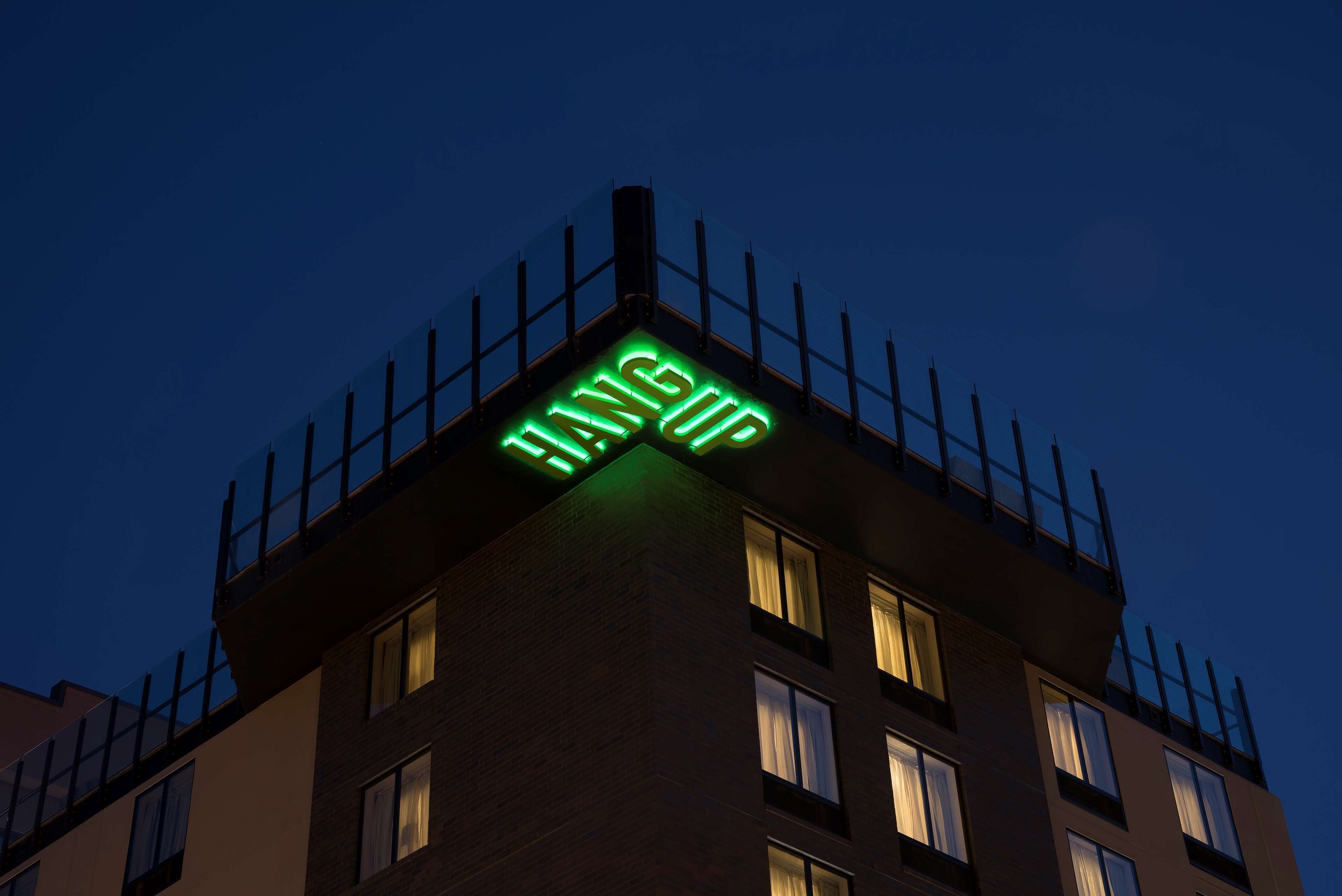Un edificio con un letrero de neón que dice 'HANGUP' en la parte superior.