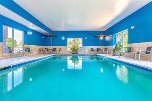 Una piscina techada, sillones reclinables de piscina