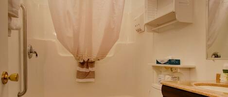 A bathroom with a bathtub, toilet, and vanity.