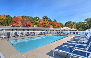 Una piscina al aire libre de temporada, sombrillas