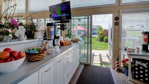 Une cuisine moderne dotée d’une grande fenêtre, d’un téléviseur et de divers ustensiles de cuisine.