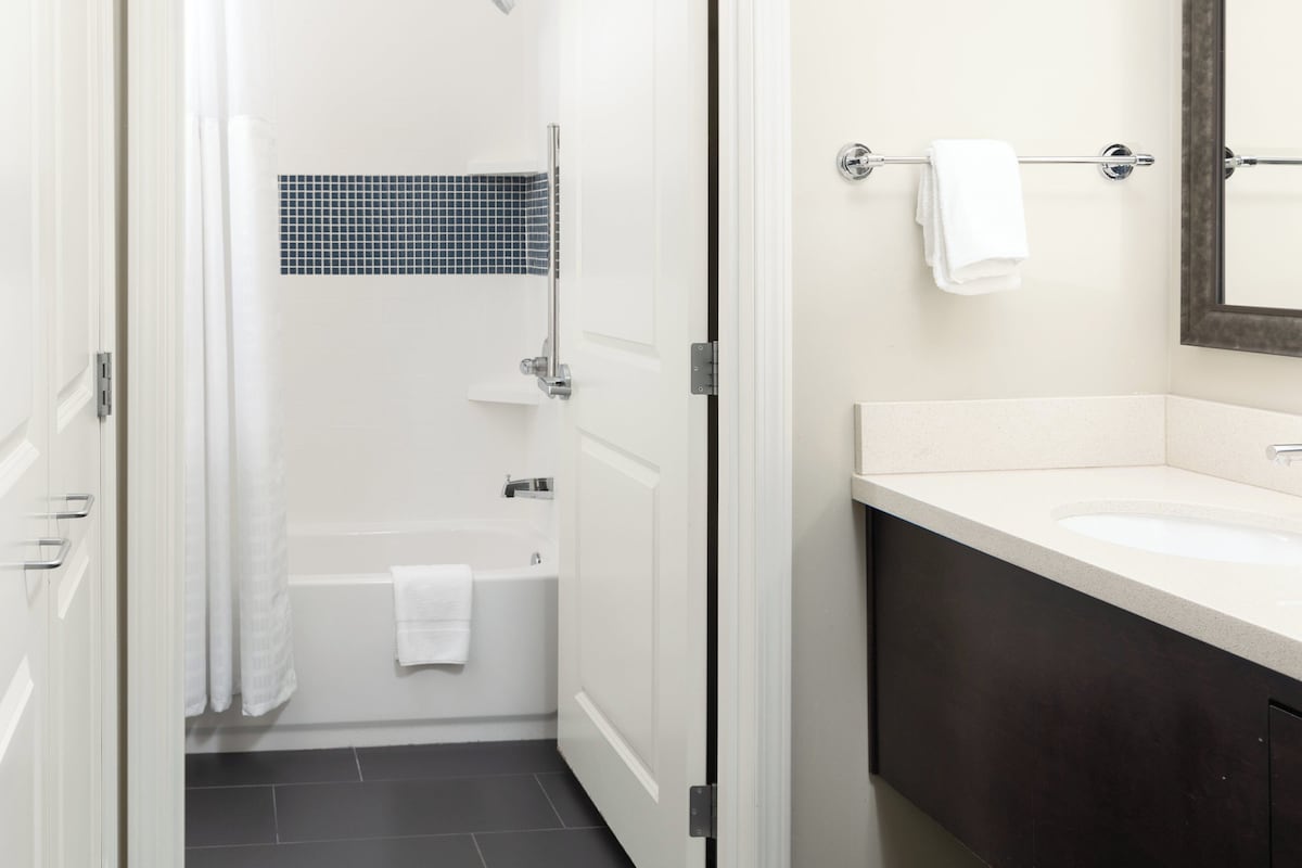 Un baño con bañera, ducha, inodoro y lavamanos.