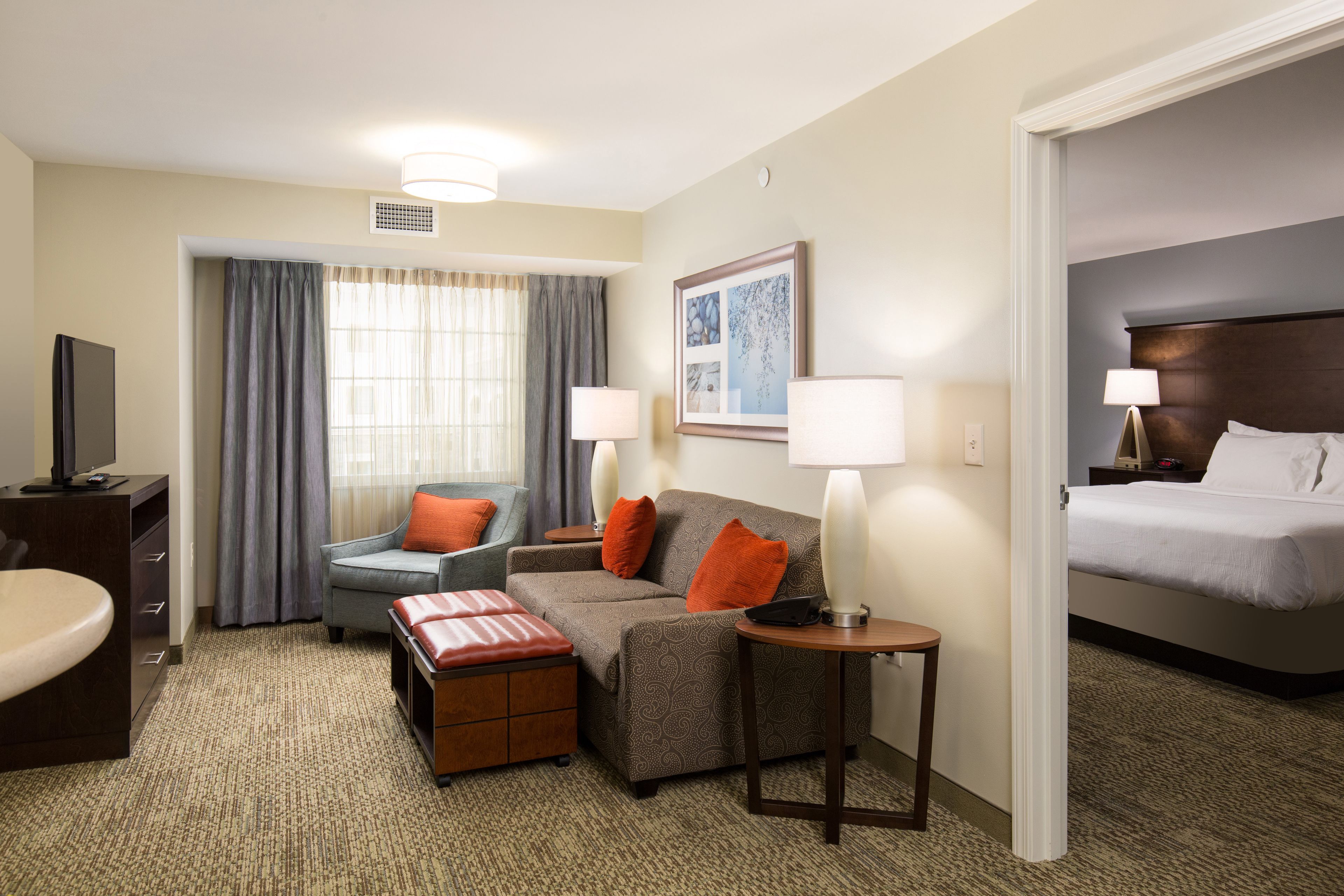 Una habitación de hotel con cama, sofá, escritorio y silla.