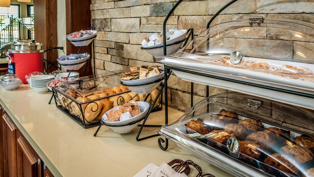 A buffet setup with various food items and a coffee station.