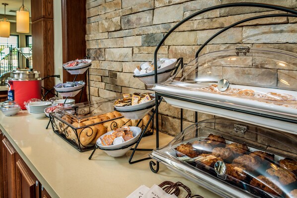 A buffet setup with various food items and a coffee station.